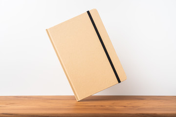 Perspective view of kraft notebook on wood floor