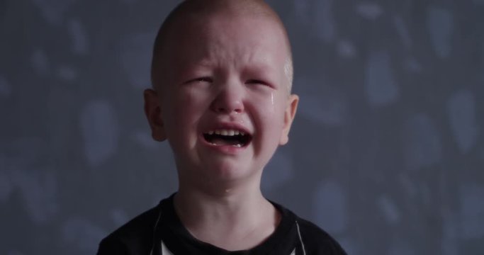 Concept of emotion. Little blond boy suddenly burst into tears. Child cry and can not calm down and confused.