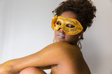 Beautiful Brazilian afro girl ready for the carnival. Golden body painting. Fashion girl with...