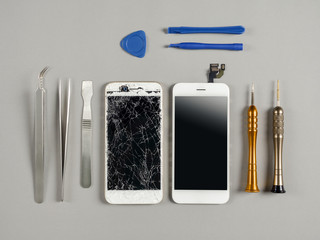 Broken and cracked screen smartphone prepairing to repair and replace new screen on technician desk