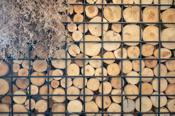 Abstract photo of a pile of natural wooden logs background in black metal frame for interior design