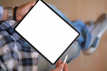 Top view of a man holding pencil and mockup blank screen digital tablet device