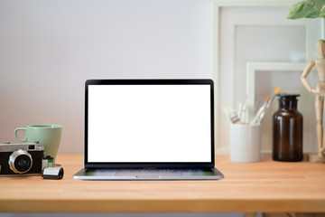 Loft wood office desk table with laptop, poster, vintage camera and supplies.