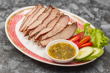 Fried pork with garlic or steak on rice and cucumber.