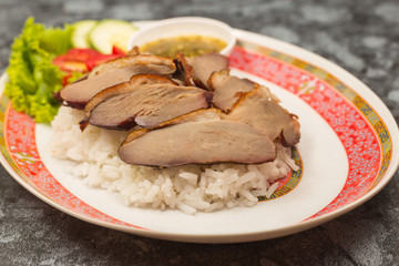 roasted duck meat topping rice dressing sweet sauce and pickled ginger on plate