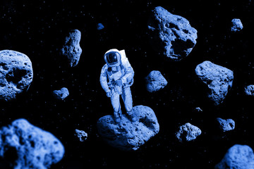 Astronaut standing on meteorites in deep space, science fiction fantasy background.