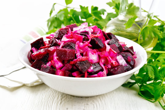 Vinaigrette with cabbage in bowl on light board