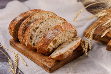 Sliced craft bread on a board close-up. The concept of healthy food and traditional bakery.