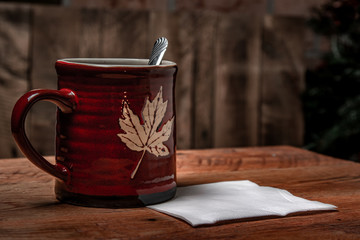 Mug with spoon and wooden background