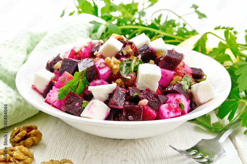 Poster salad with beetroot and apple in plate on board