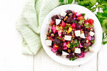 Salad with beetroot and feta in plate on board top