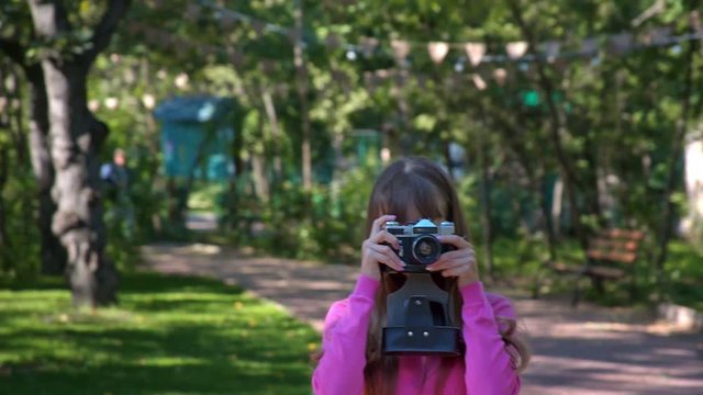 Girl with retro camera outdoors