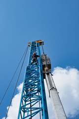 Worker wear orange helmet climb very high crane in hot day for pile.