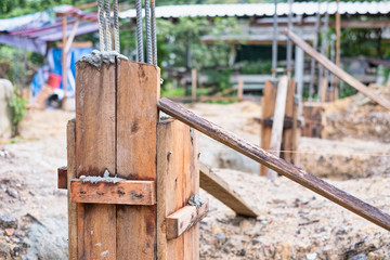 Pillar blocks for foundation made from plank on construction site.