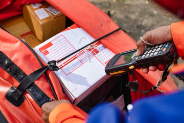 Young modern delivery man use barcode scanner on delivery work time.