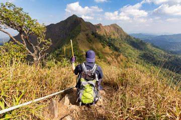 You man sit taking a rest after long walk of trekking. Mountain in Thailand, Khao Chang Puak in Kanchanaburi province.