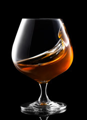 splash of cognac in snifter glass