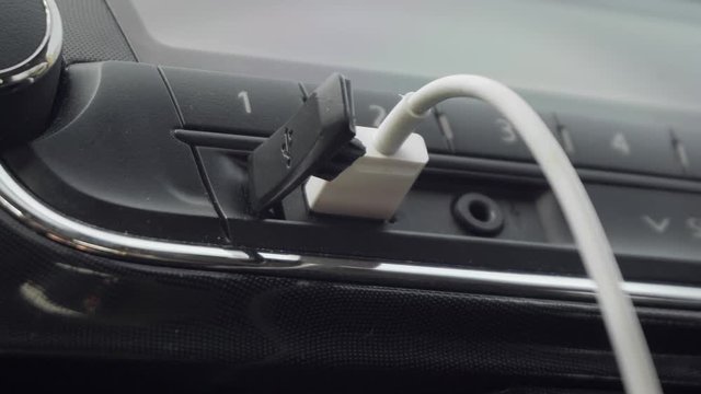 Female Hand Inserting USB Cable in Car