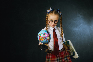 Fototapeta premium Portrait of a girl primary school student on a dark background