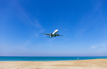 Commercial airplane landing above sea and clear blue sky over beautiful scenery nature background...