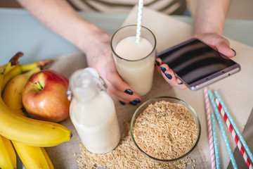 Rice milk in a glass Cup and fruit with scattered grains of rice on table in the kitchen. Healthy vegetarian product