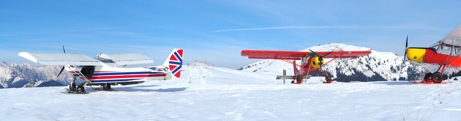 Monte Pora, Bergamo, Italy. A single engined, light aircrafts parked on a snow covered plateau. Red...