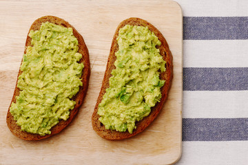 sandwich with guacamole on wood top view