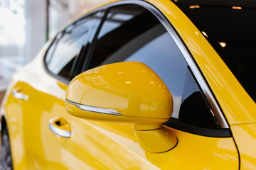 Chrome yellow car design elements - rear-view mirror and the right side of the body