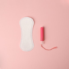 Menstruation concept on pink living coral background - Feminine hygiene pad and tampon