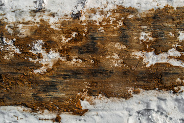 Snow and soil. Clay. Background of snow. Brown and white