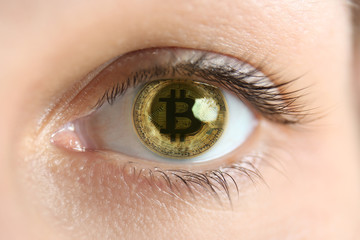 Reflection of bitcoin in female eye, closeup