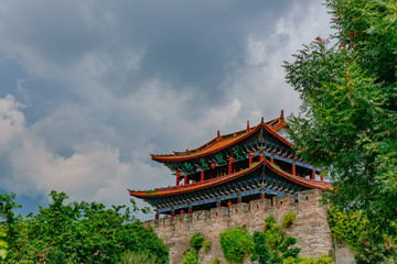 Fototapeta na wymiar Traditional Chinese gate tower building in old town of Dali under sky and clouds, in Dali, Yunnan, China