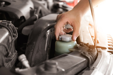 Auto mechanic repairing car in service center, closeup