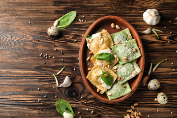 Plate with tasty ravioli on wooden table