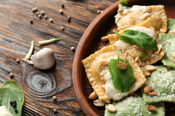 Plate with tasty ravioli on wooden table