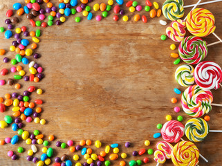 Frame made of different sweets on wooden background
