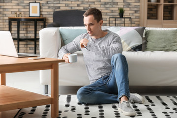 Fototapeta premium Handsome young man drinking coffee at home