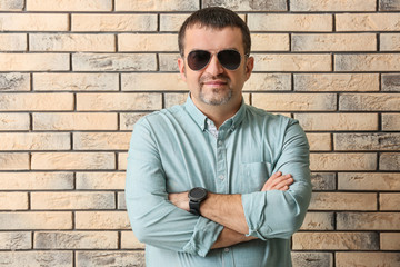 Handsome mature man near brick wall
