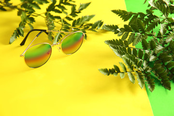 Stylish sunglasses on color background