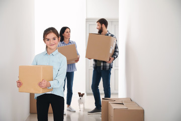 Family with cardboard boxes moving into new house