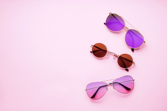 Different stylish sunglasses on color background