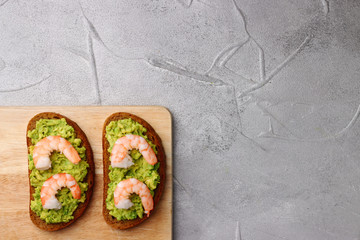 sandwich with shrimp and avocado on light background