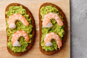 sandwich with shrimp and avocado on light background
