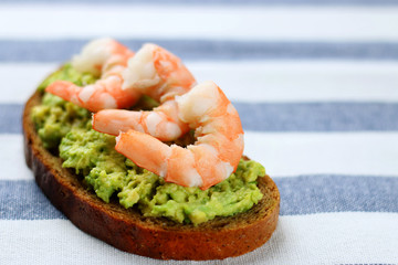 shrimp and avocado on bread with light background healthy breakfast