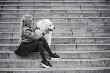 Lovely girl on a walk with a beautiful dog - obrazy, fototapety, plakaty