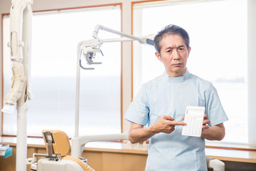 電卓を指差す歯医者さん