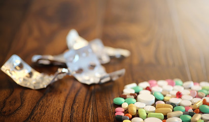 Drugs and coins in a glass jar on a wooden floor. Pocket savings from coins in a bank for medical services. Piggy bank in a glass jar with coins.