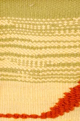 Horizontal fragment of tapestry with wool threads. Colorful fabric texture with stripes and lines in warm colors. Multi colored background with close up of a traditional beautiful textile.