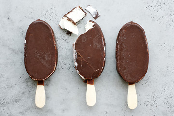 Chocolate ice cream popsicles. Gray background, Flat lay