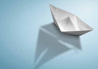 maritime travel concept, paper ship with sailing boat shadow
